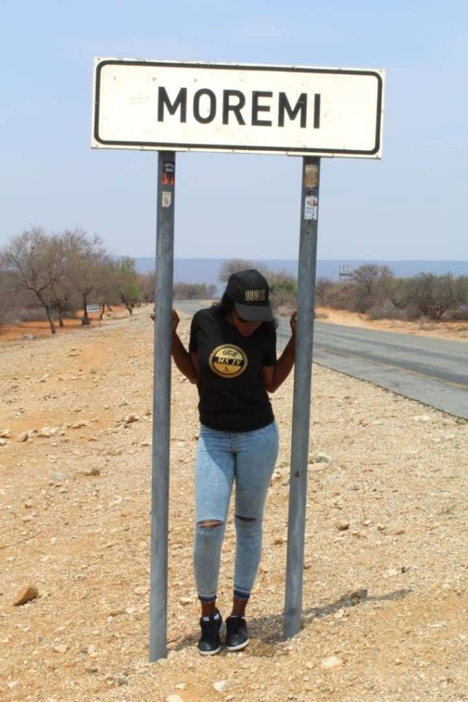 TTraveyola Goo-Moremi Tour Experience Lady at Moremi Sign
